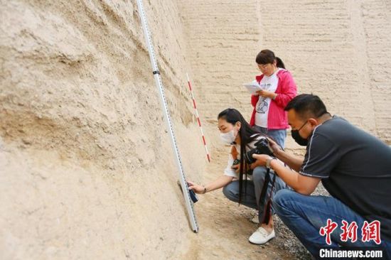 科技保護讓長城價值的真實性和完整性得到有效延續(xù)和傳承。圖為文物工作者正在測量關城的相關數(shù)據(jù)。　高展 攝