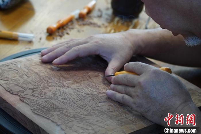 圖為徐晉林湊近木板，近距離制作雕版畫?！【琶赖┰?　攝