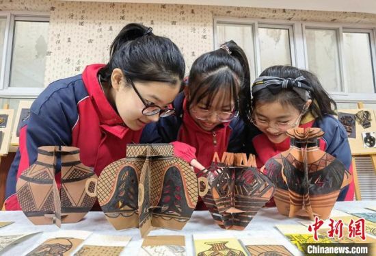 圖為學(xué)生用紙創(chuàng)作的立體彩陶?！⒂裉?攝