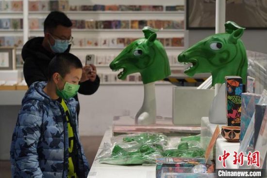 圖為“神馬來了”銅奔馬頭套吸引參觀者駐足?！【琶赖┰?攝
