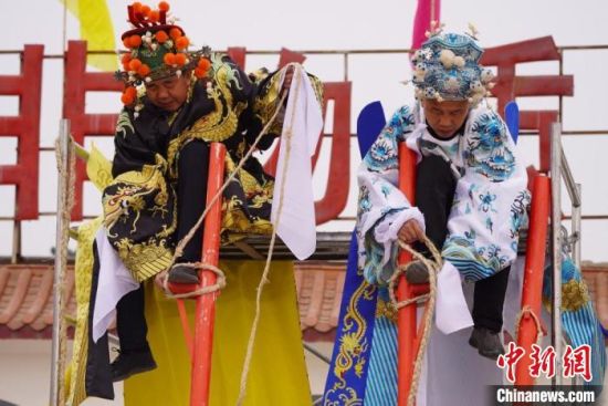 圖為“苦水高高蹺”表演者通過麻繩將腳固定在腳踏板，并在腿部纏繞六七圈?！【琶赖┰?攝