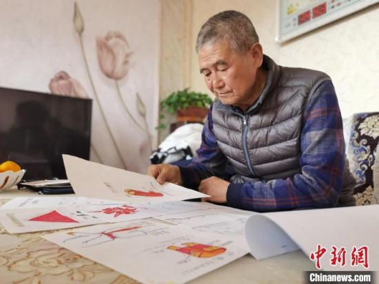 圖為陸鵬飛向記者展示多年帶隊(duì)的手寫筆記?！堟?攝