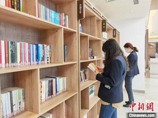 圖為在甘肅公航旅建設(shè)集團(tuán)有限公司的職工書屋，職工挑選書籍?！⌒煅?攝