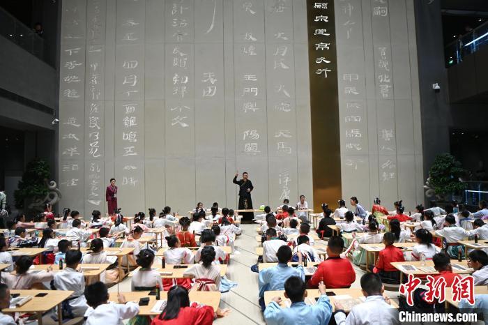 圖為9月7日，甘肅簡牘博物館開館儀式在蘭州舉行，小朋友們學(xué)習(xí)書寫簡牘中的文字。　中新社記者 九美旦增 攝