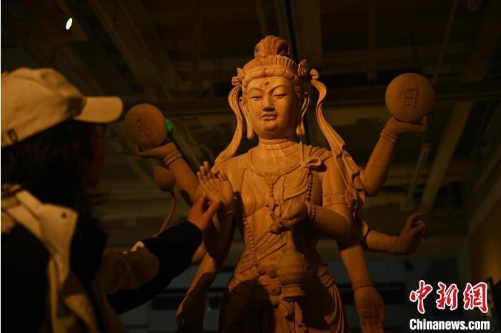 圖為季茂杰觀察自己創(chuàng)作的敦煌木雕。李亞龍 攝</p>
<p>