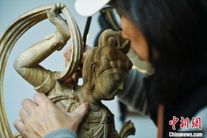 圖為季茂杰進(jìn)行敦煌元素的木雕創(chuàng)作。李亞龍 攝</p>
<p>