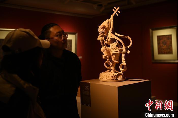 圖為季茂杰向參觀者介紹自己創(chuàng)作敦煌木雕的過(guò)程。李亞龍 攝</p>
<p>