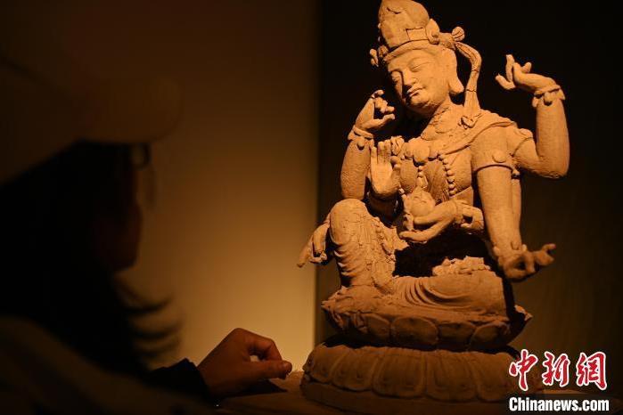 圖為季茂杰觀察自己創(chuàng)作的敦煌木雕。李亞龍 攝