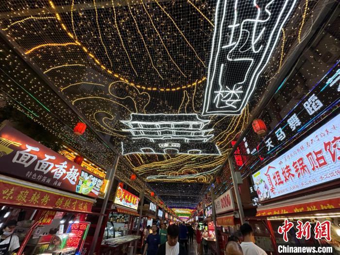 圖為明清街夜市燈光點(diǎn)亮具有武威文化元素的“涼州古城門”彩燈?！〈魑牟?攝</p><p>