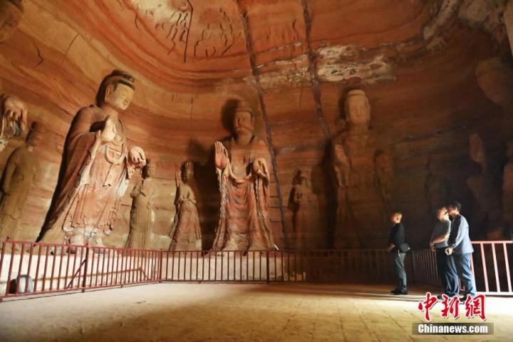 7月15日，游人參觀(guān)甘肅省平?jīng)鍪袥艽h百里石窟長(zhǎng)廊中的南石窟寺1號(hào)窟。百里石窟長(zhǎng)廊位于涇川縣境內(nèi)，由512個(gè)石窟、5眼窟中石井組成，現(xiàn)存王母宮石窟、鳳凰山石窟、南石窟寺、丈八寺石窟、羅漢洞石窟、太山寺石窟等規(guī)模較大的石窟群，還有數(shù)量眾多的小石窟群。南石窟寺開(kāi)鑿于北魏永平三年，其中1號(hào)窟屬于大型七佛窟，七佛高達(dá)6米。中新社記者 李亞龍 攝