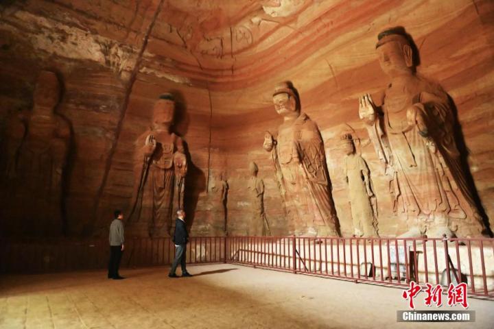 7月15日，游人參觀(guān)甘肅省平?jīng)鍪袥艽h百里石窟長(zhǎng)廊中的南石窟寺1號(hào)窟。百里石窟長(zhǎng)廊位于涇川縣境內(nèi)，由512個(gè)石窟、5眼窟中石井組成，現(xiàn)存王母宮石窟、鳳凰山石窟、南石窟寺、丈八寺石窟、羅漢洞石窟、太山寺石窟等規(guī)模較大的石窟群，還有數(shù)量眾多的小石窟群。南石窟寺開(kāi)鑿于北魏永平三年，其中1號(hào)窟屬于大型七佛窟，七佛高達(dá)6米。中新社記者 李亞龍 攝