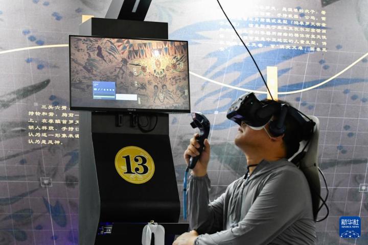 7月22日，游客借助VR設(shè)備沉浸式游覽莫高窟第285窟虛擬場景。新華社記者 郎兵兵 攝
